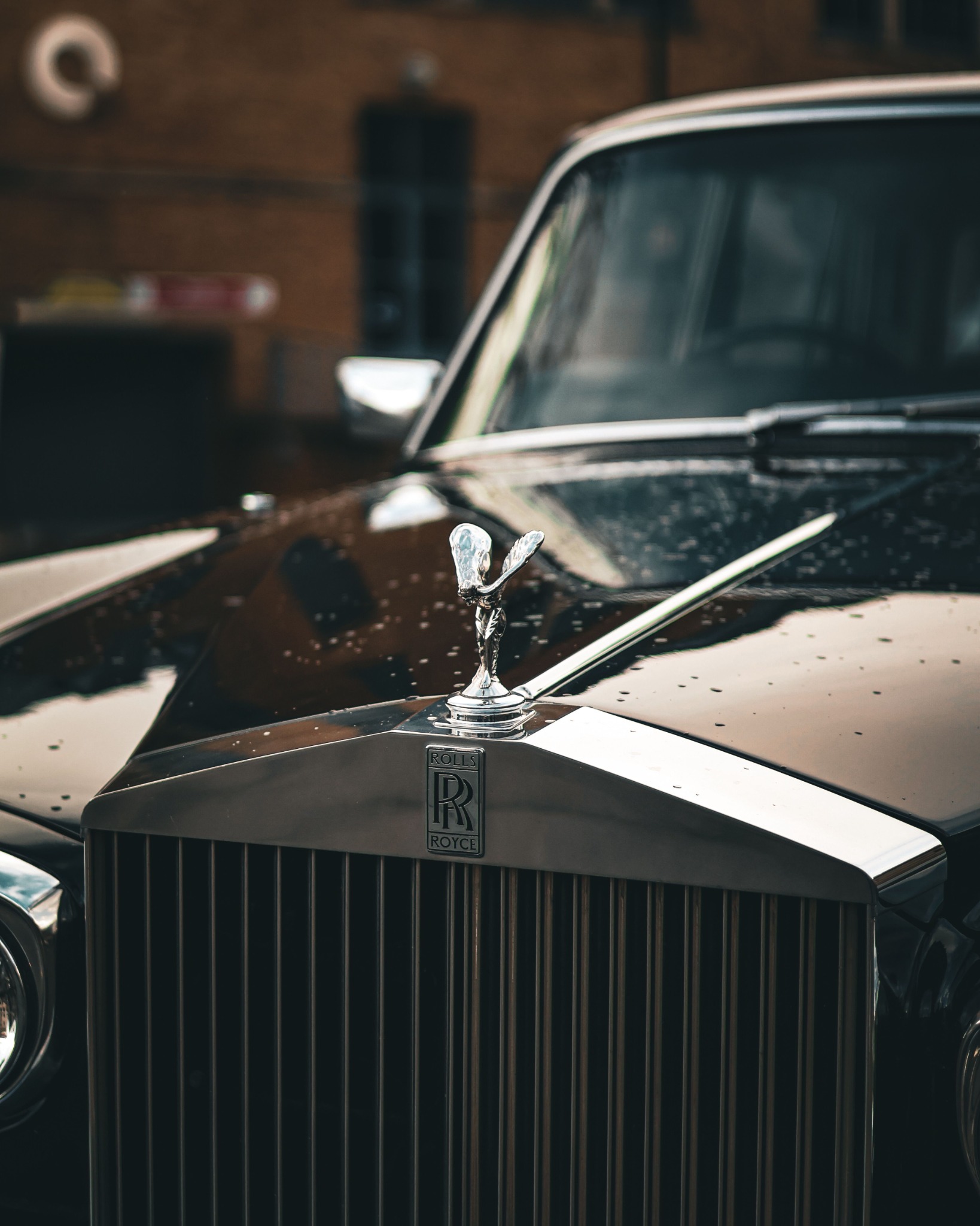 Close view of the Spirit of Ecstasy mascot and double R badge on a Rolls-Royce grille