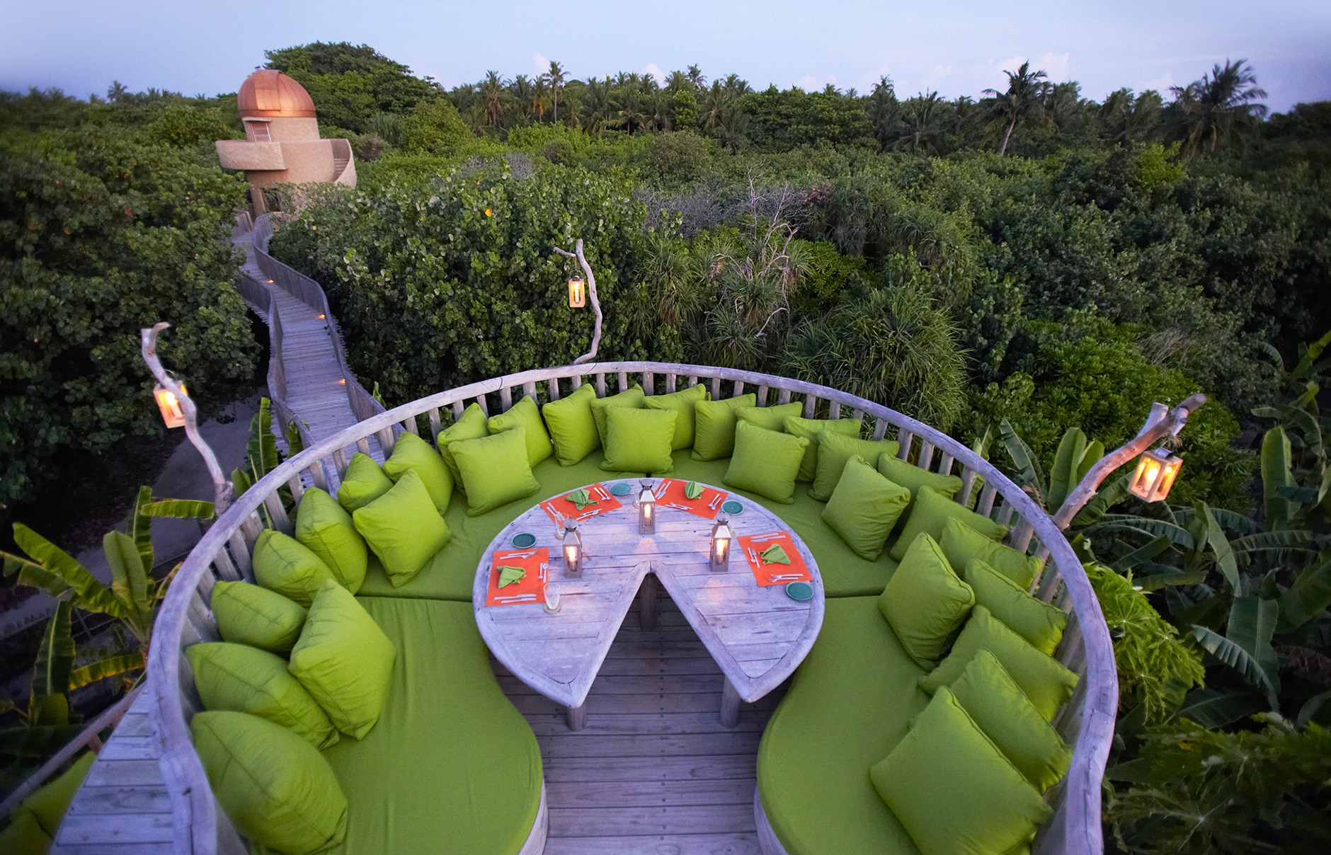 Open-air dining terrace surrounded by trees at Soneva Fushi